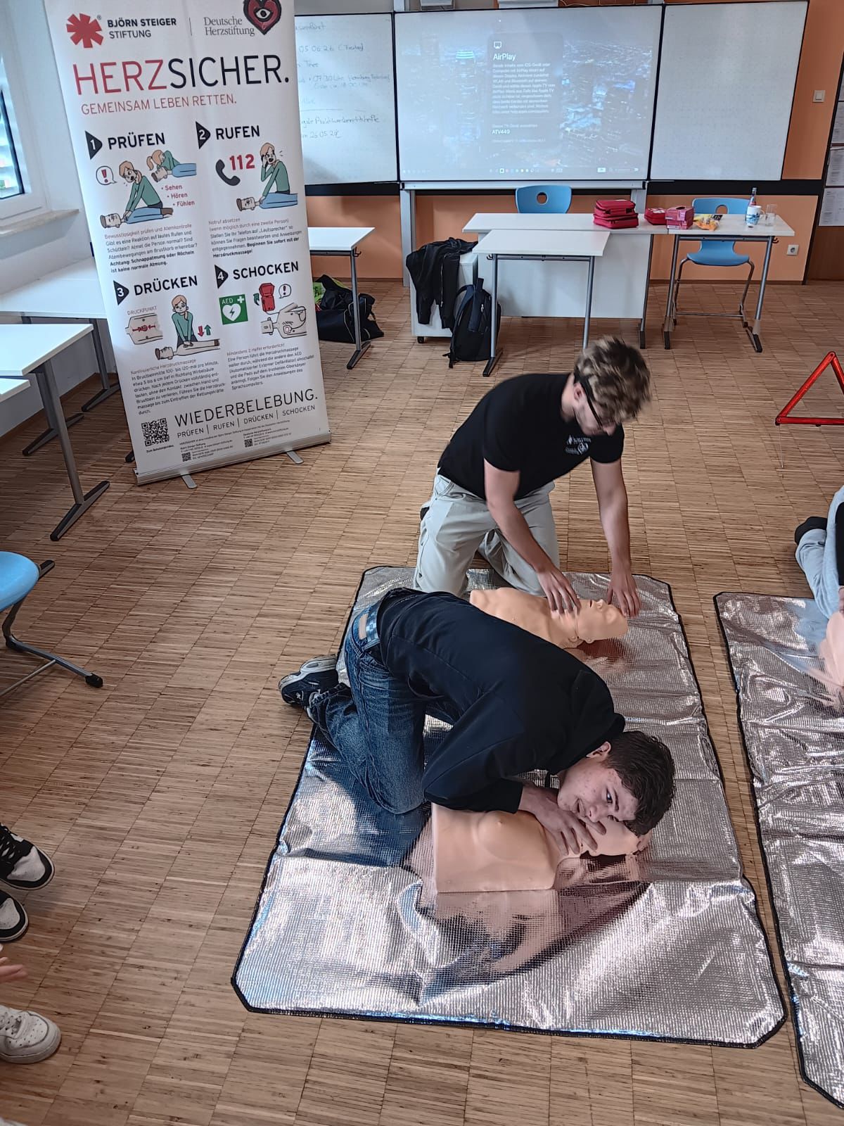 Ersthelfende üben die Herzdruckmassage am Übungsmodell
